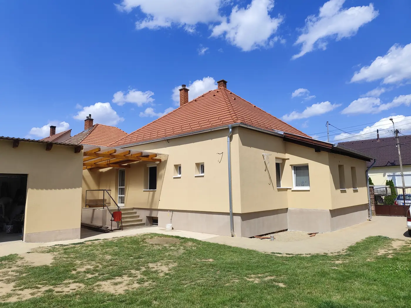 Elkészült, sárga színezésű családi ház hátsó homlokzata