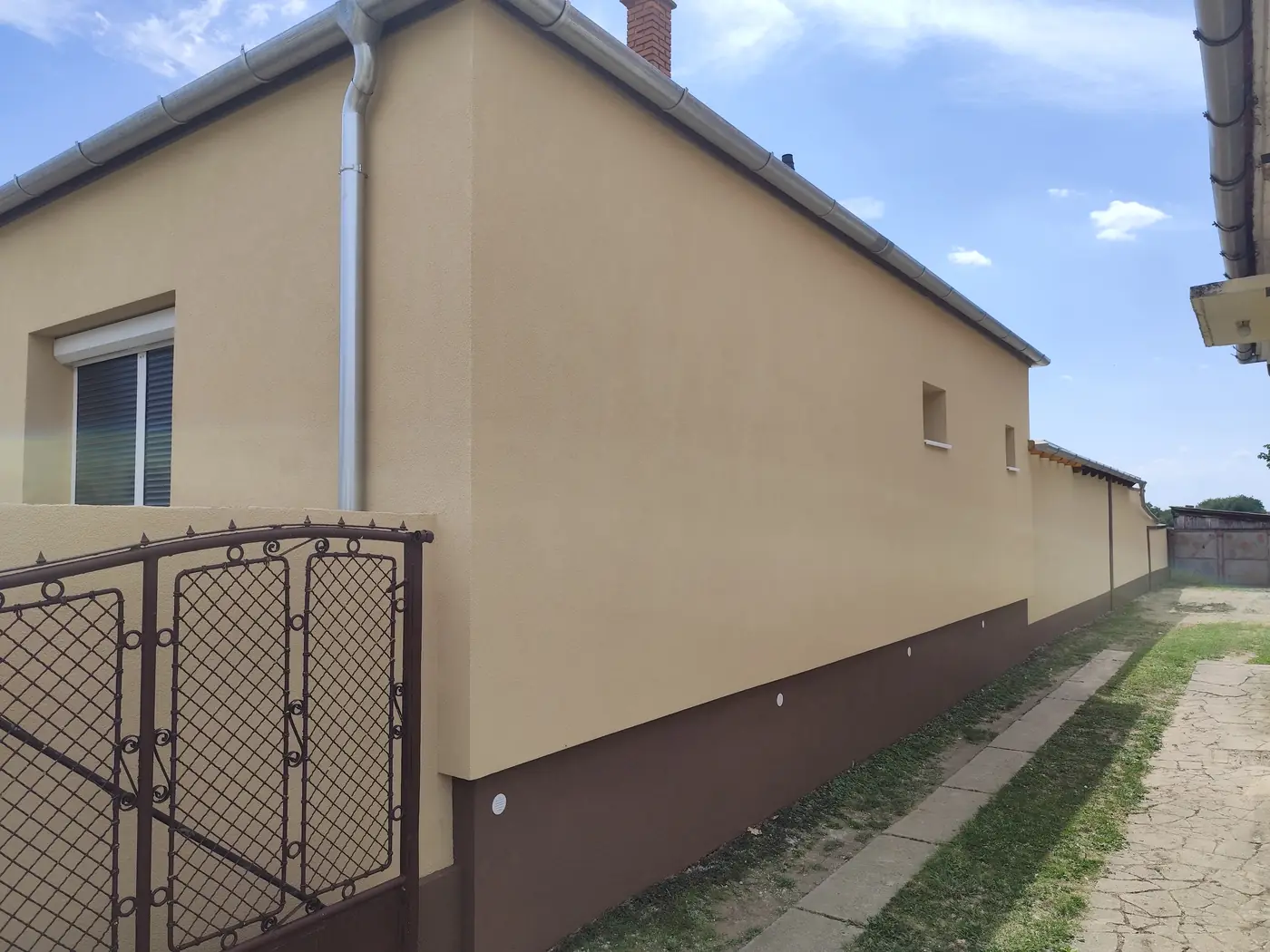 Elkészült homlokzat barna lábazattal, oldalnézet